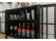 Black bar cabinet stocked with liquors and glasses at , Indianapolis, IN 46221