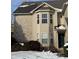 Tan brick and vinyl sided home with a bay window and snowy front yard at 706 Shagbark Ct, Plainfield, IN 46168