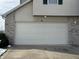 Attached two-car garage with light beige doors and brick facade at 706 Shagbark Ct, Plainfield, IN 46168