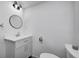 Small bathroom with white vanity and round mirror at 940 W 53Rd St, Indianapolis, IN 46208