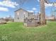 Large backyard with a multi-level deck, surrounded by green grass and mature trees at 11237 Baycreek Dr, Indianapolis, IN 46236