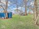 Spacious backyard featuring a green lawn, mature trees, and a blue storage shed at 11237 Baycreek Dr, Indianapolis, IN 46236