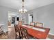 Charming dining room with elegant chandelier and wood-look flooring, adjacent to living area at 11237 Baycreek Dr, Indianapolis, IN 46236