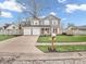 Inviting two-story home featuring a two-car garage, a lovely lawn, and mature trees at 11237 Baycreek Dr, Indianapolis, IN 46236