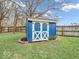 The backyard shed with blue siding and white trim offers extra storage at 11237 Baycreek Dr, Indianapolis, IN 46236
