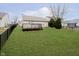 Spacious backyard with manicured lawn, wood deck, and black metal fence at 12243 Carriage Stone Dr, Fishers, IN 46037