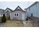 Gray single Gathering home featuring a side yard, a small garden, and a side entrance with a storm door at 1719 Fletcher Ave, Indianapolis, IN 46203