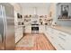 Bright kitchen features white cabinets, stainless steel appliances, subway tile backsplash and hardwood floors at 1719 Fletcher Ave, Indianapolis, IN 46203