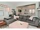 Inviting living room features a plush gray sectional, light-filled windows and open access to the kitchen at 1719 Fletcher Ave, Indianapolis, IN 46203