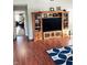 Spacious living room featuring hardwood floors, built-in shelving, and a large TV at 2188 S Briarwood Dr, New Palestine, IN 46163