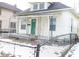 Charming white house with green door, covered porch, and chain link fence at 316 N Lasalle St, Indianapolis, IN 46201