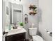Small bathroom with dark vanity, white toilet, and floating shelves at 373 Brianne Ln, Danville, IN 46122