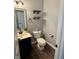 Charming half bathroom with a black vanity, open wood shelving, and wood-look flooring at 373 Brianne Ln, Danville, IN 46122