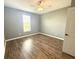 A bedroom featuring light gray walls, wood floors, a ceiling fan and a window at 373 Brianne Ln, Danville, IN 46122