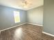 A bedroom featuring light gray walls, wood floors, a ceiling fan and a window at 373 Brianne Ln, Danville, IN 46122