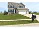 Two-story home with gray brick and siding, green lawn, and mailbox at 373 Brianne Lane at 373 Brianne Ln, Danville, IN 46122