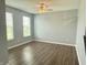 Sunlit room with hardwood floors, two large windows, and a ceiling fan, offering a simple, neutral space at 373 Brianne Ln, Danville, IN 46122