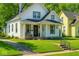 Charming two-story home featuring a covered porch and beautifully landscaped front yard and black trimmed windows at 3816 Rookwood Ave, Indianapolis, IN 46208