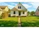 Well-kept home with a green door and a simple, tidy front yard with ample sunshine at 3816 Rookwood Ave, Indianapolis, IN 46208