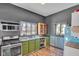 Rustic kitchen with green cabinets, stainless steel appliances, and exposed brick at 3816 Rookwood Ave, Indianapolis, IN 46208