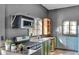 Rustic kitchen with green cabinets, brick walls, and gas stove at 3816 Rookwood Ave, Indianapolis, IN 46208