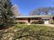Charming brick home with well-maintained lawn and mature landscaping under a blue sky at 6628 E Michigan St, Indianapolis, IN 46219