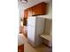 Kitchen area with white refrigerator and wood cabinets at 6628 E Michigan St, Indianapolis, IN 46219