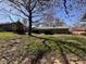 The backyard of this brick house features a well-kept lawn and mature trees offering shade at 6628 E Michigan St, Indianapolis, IN 46219