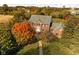 Aerial view of a stately brick home with a well-manicured lawn and colorful fall foliage at 8552 E 550 S, Zionsville, IN 46077