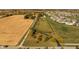 Aerial view of a property with a long driveway, fenced pasture, and mature trees, nestled between farmland and neighborhood at 8552 E 550 S, Zionsville, IN 46077