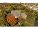 Aerial view showcasing the elegant brick home surrounded by colorful fall foliage and a well-manicured lawn at 8552 E 550 S, Zionsville, IN 46077