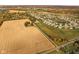 Aerial image showcases home nestled between farmland and a developed neighborhood, with scenic surroundings and easy access to both at 8552 E 550 S, Zionsville, IN 46077