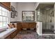 Modern bathroom featuring a glass-enclosed shower, a vanity with a large mirror, and a bench seat at 8552 E 550 S, Zionsville, IN 46077