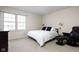 Neutral bedroom with a white bed, black pillows, accent chair, and a bright window at 8552 E 550 S, Zionsville, IN 46077