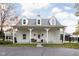 Exterior shot featuring the barn's covered porch, dormer windows, and farmhouse charm in a serene setting at 8552 E 550 S, Zionsville, IN 46077