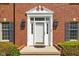 Close-up of a front door with decorative trim, sidelights, and black lanterns, set in a classic brick facade at 8552 E 550 S, Zionsville, IN 46077