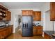Kitchen with custom wooden cabinets, granite countertops, stainless steel refrigerator, and hardwood floors at 8552 E 550 S, Zionsville, IN 46077