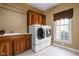 Bright laundry room features modern washer and dryer units, wooden cabinets and countertops, and a window at 8552 E 550 S, Zionsville, IN 46077