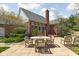 Backyard patio with wooden dining furniture, stone details, and a view of the house at 8552 E 550 S, Zionsville, IN 46077