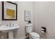 Charming powder room featuring pedestal sink, classic toilet, and decorative wall art at 8552 E 550 S, Zionsville, IN 46077