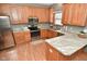 L-shaped kitchen with oak cabinets and granite countertops at 861 Stardust Ct, Franklin, IN 46131
