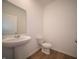 Well-lit half bathroom with pedestal sink and a toilet at 8703 Duncan St, Fortville, IN 46040