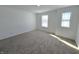 Bright bedroom with neutral carpeting and two windows at 8703 Duncan St, Fortville, IN 46040