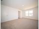 A bright bedroom with plush carpeting and a window; a door provides access to other areas of the home at 8703 Duncan St, Fortville, IN 46040