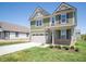 Well-maintained two-story home with a two-car garage and a neatly landscaped front yard at 8703 Duncan St, Fortville, IN 46040
