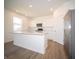 Well-lit kitchen featuring white cabinets, stainless steel appliances, a spacious island, and wood-look flooring at 8703 Duncan St, Fortville, IN 46040