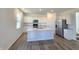 Bright, open kitchen with white cabinets, stainless steel appliances, and a center island at 8703 Duncan St, Fortville, IN 46040