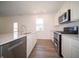 Contemporary kitchen featuring stainless steel appliances, light countertops, and wood-look flooring at 8703 Duncan St, Fortville, IN 46040