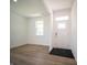 Bright and airy living room with wood-look flooring and a white front door at 8703 Duncan St, Fortville, IN 46040