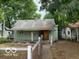 Green bungalow home with front porch and small yard at 1035 S Tremont St, Indianapolis, IN 46221
